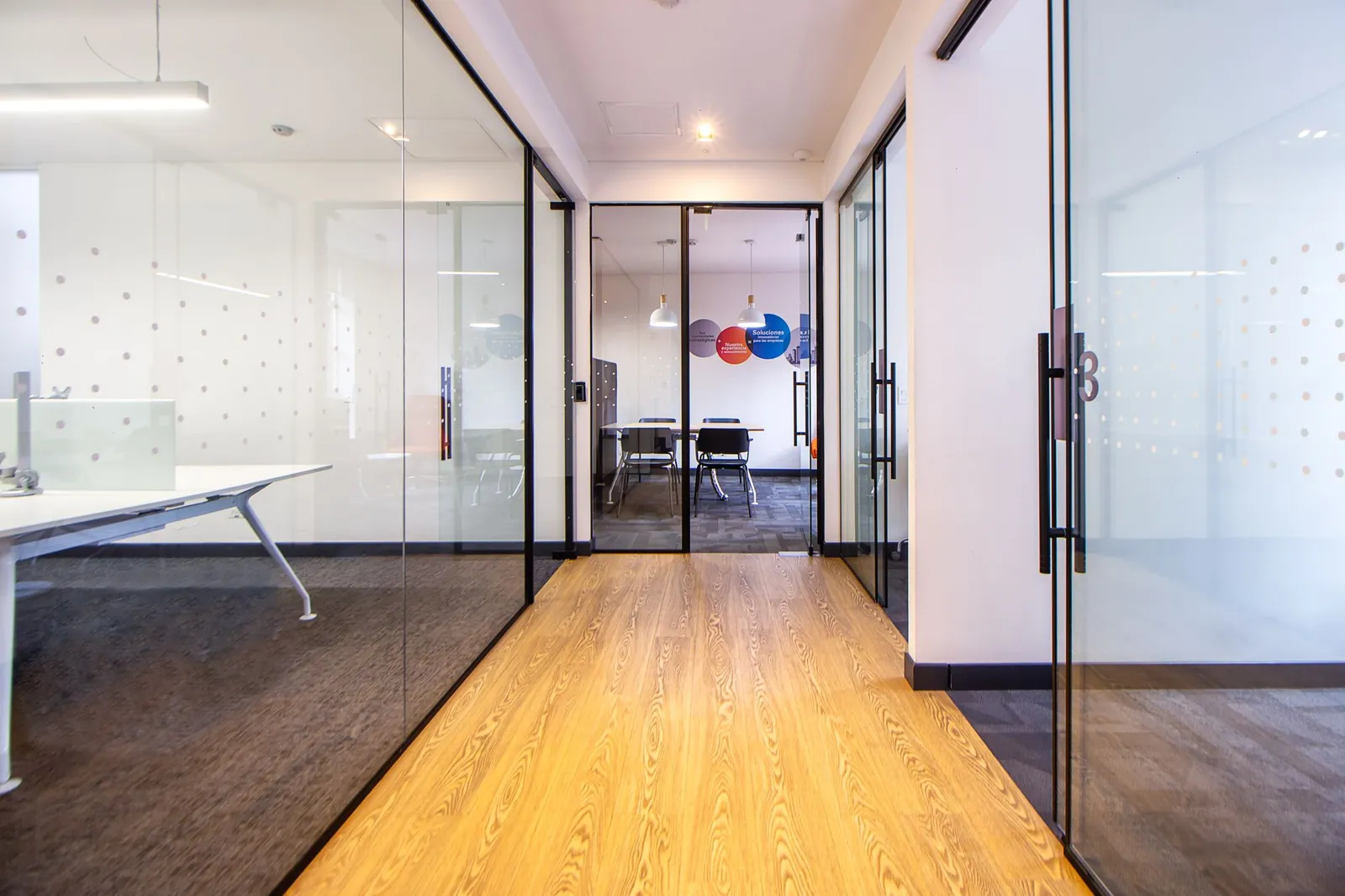 Office hallway with glass walls and wood look flooring